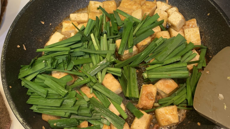 韭菜炒豆腐,放入韭菜段,翻炒均匀,就可出锅