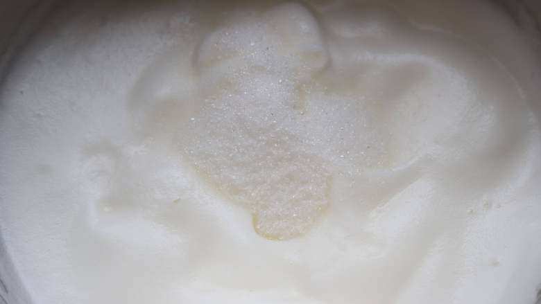 蓝莓戚风,蛋白略微出现纹路的时候,第三次加入20克细砂糖,用低速继续搅打。