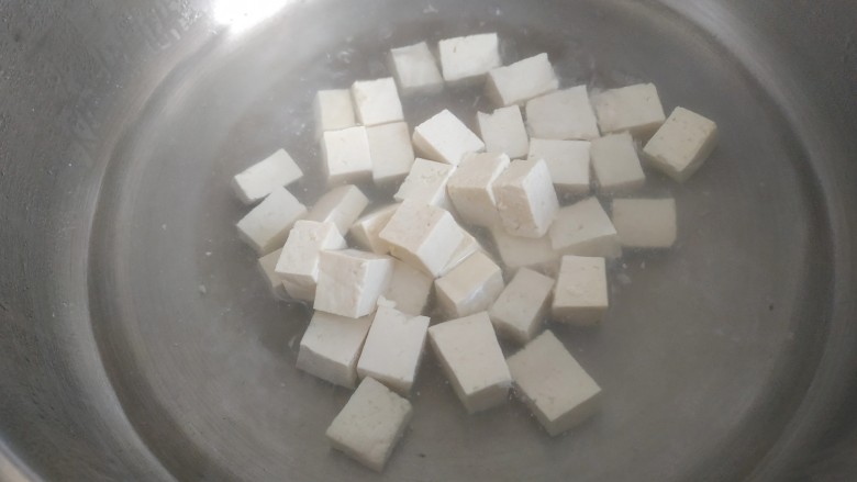 韭菜炒豆腐,锅中放入适量清水烧开,放入豆腐烧几分钟