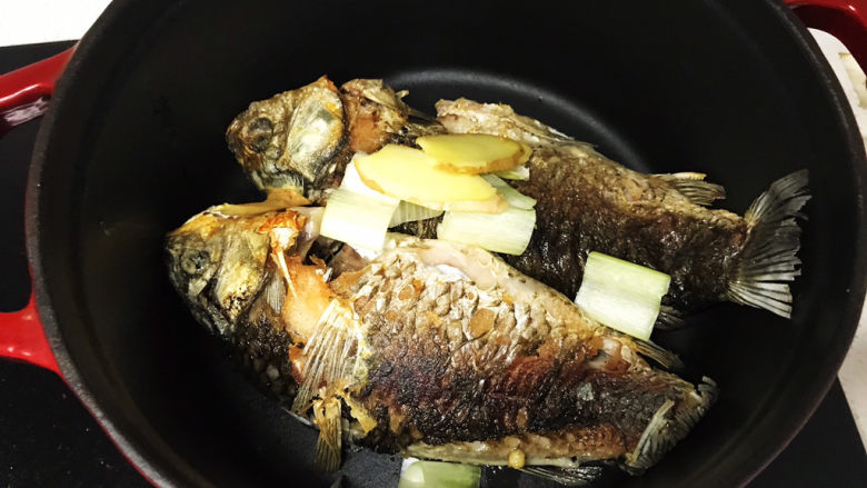 奶白鲫鱼豆腐汤,放入葱段和姜片;