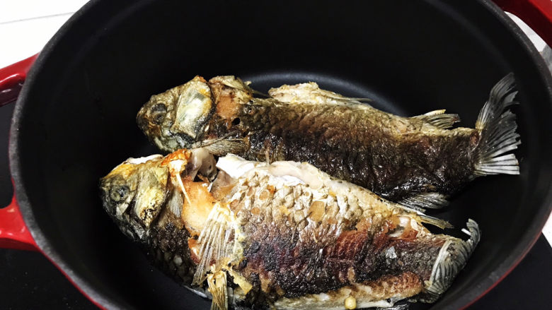 奶白鲫鱼豆腐汤,鱼煎好后移到预热好的铸铁锅或者砂锅里;