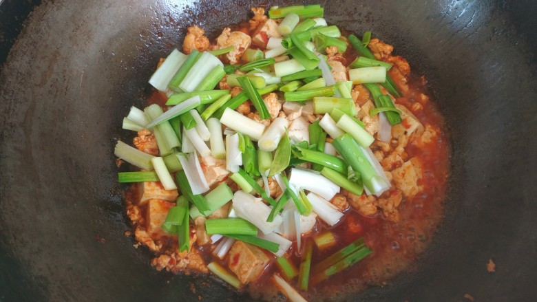 蒜苗鸡肉烧豆腐,汤汁变少，放入蒜苗