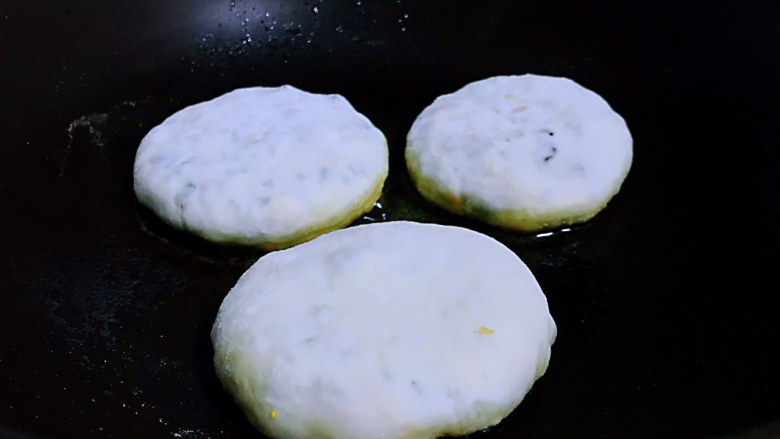 鲜韭菜馅饼,平底锅烧热,刷入一层薄薄的油,也可以用电饼铛,调为小火把饼放进去,底部金黄时翻面。