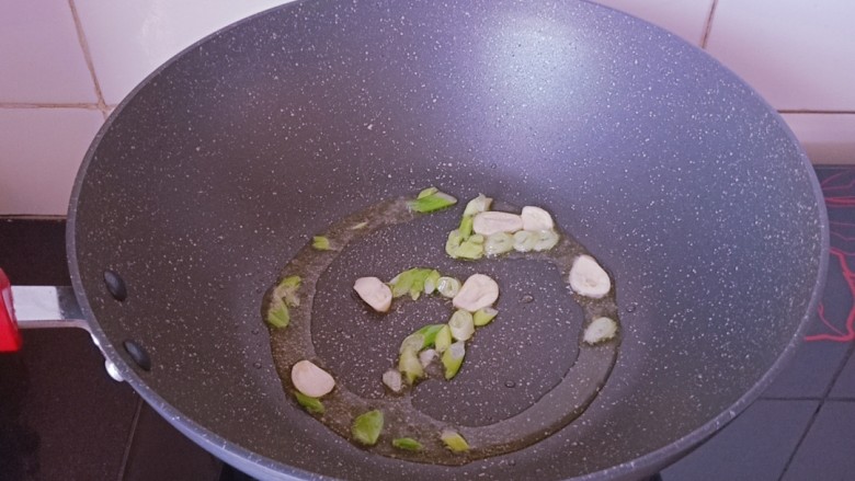 秋葵炒鸡蛋,锅内再次淋入少许食用油烧热,放入葱蒜片炒香。