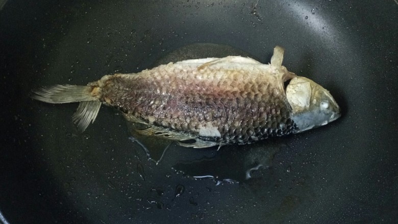 酱焖鲫鱼,鱼腌好用厨房纸巾吸干水份,锅中倒入适量油烧热,放入鱼煎至两面金黄,盛出备用