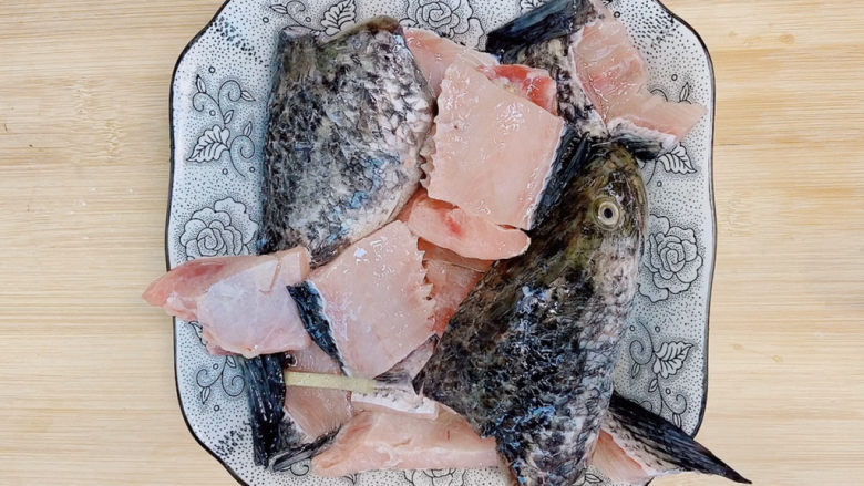 家庭水煮鱼,鱼骨另外用一个碟装好,也加入料酒和姜腌制去腥。