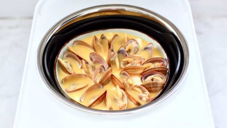 飞蛤豆腐鸡蛋羹,臻米脱糖蒸汽养生饭煲的内胆里加入清水,水位线不要超过2刻度,饭煲的内胆的箭头要对齐锅里的箭头,这个时候再放入洗净的甑胆放入,把碗放入甑胆中间。