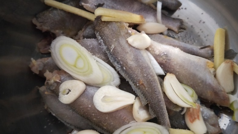 红烧小黄鱼,加入葱姜蒜,料酒,盐。