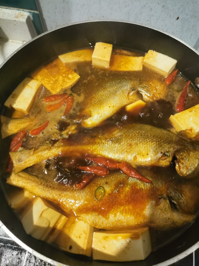 黄鱼炖豆腐,热锅,锅热后倒油。下葱姜蒜、干辣椒、豆瓣酱爆炒,炒香后鱼下锅,稍微煎下后放料酒(我喜欢多放点)。然后放生抽、老抽、蚝油、糖、醋、鸡精(具体多少看自己口味哦哦,有的也可以不放,我个人喜欢都放点,啦啦啦)。加水没过鱼,放入豆腐。盖锅盖,大火。炖10-15分钟左右出锅。中途要用锅铲试下锅底有没有粘连。
