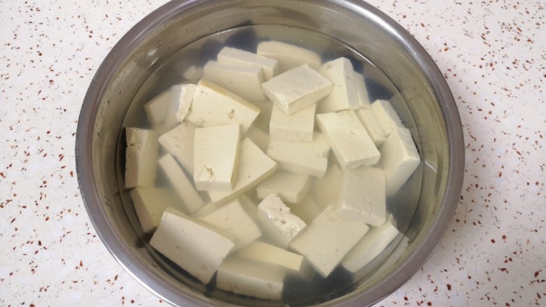 韭菜炒豆腐,放入淡盐水里面浸泡15分钟左右(用淡盐水浸泡可以去除豆腐的豆腥味,也可以让豆腐入一点底味)。