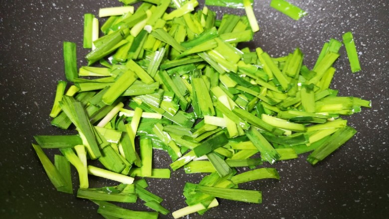 韭菜炒豆腐,将煎豆腐剩余的油继续加热,下入韭菜翻炒至变色。