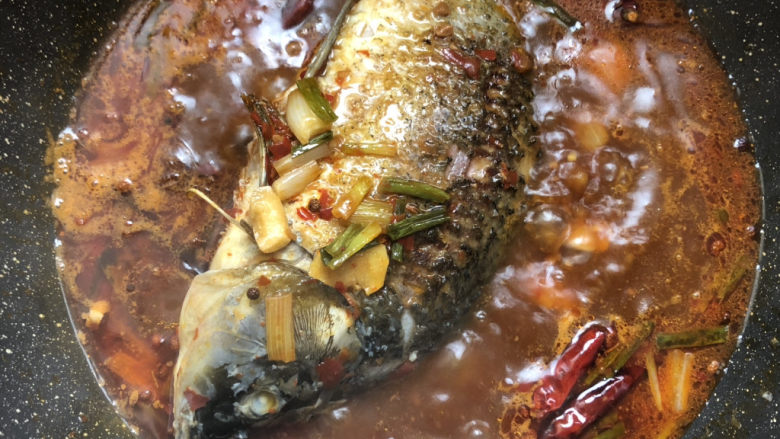 酱焖鲫鱼,烧开后放入鲫鱼,中途打开淋一些汤汁到鱼身上,方便入味