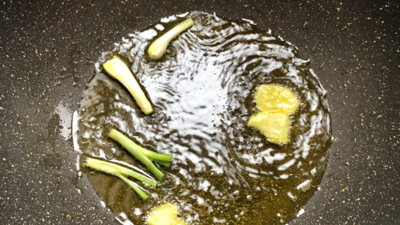 酱焖鲫鱼,起锅热油,放入葱姜炸焦香捞出料渣留底油
