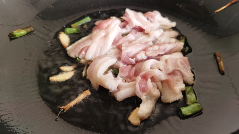 芦笋炒肉片,炒锅放油烧热,加入葱姜爆香,然后加入肉片翻炒。