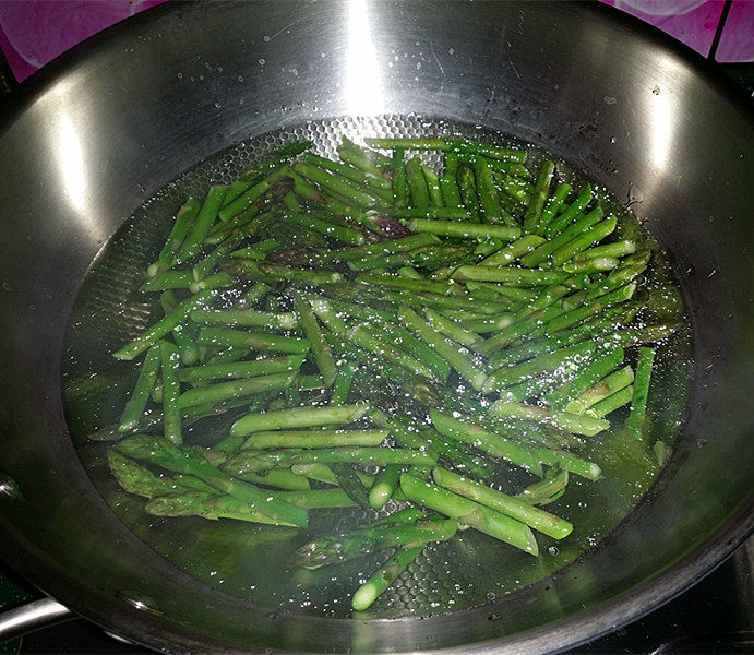 芦笋炒肉片,锅中水烧开,加入油和盐,再放入芦笋焯烫至变色后捞出过一遍凉水