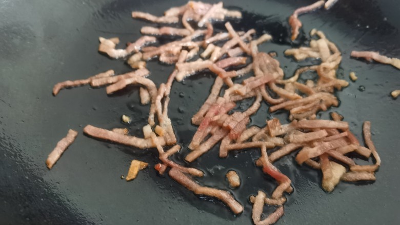 茼蒿炒鸡蛋,炒锅放油,放入培根煸炒出油,把培根特有的香味炒出来。