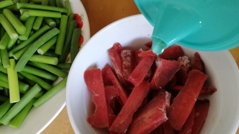 蒜苔炒牛肉,倒入一勺油,抓匀。