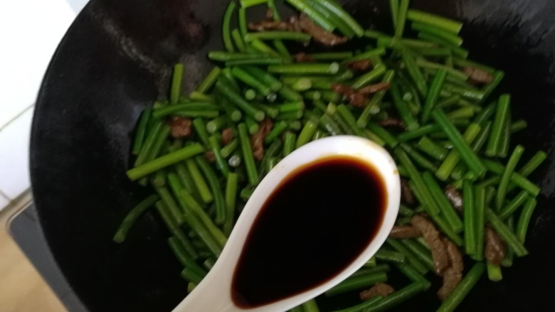 蒜苔炒牛肉,蒜薹炒到出噼啪声,沿锅边淋上一勺酱油。