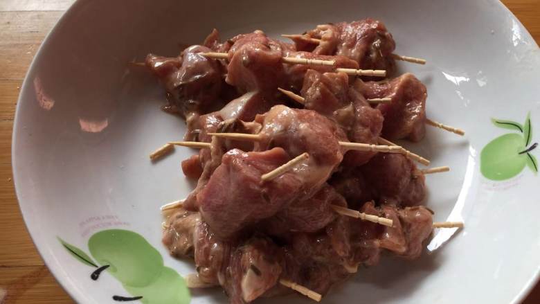 牙签羊肉,
用牙签把腌好的羊肉块串起来,表面撒少许白芝麻