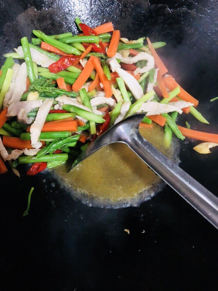 芦笋炒肉片,翻炒均匀后加入<a style='color:red;display:inline-block;' href='/shicai/ 718'>料酒</a>拌匀,再加入适量开水煮一下,使各个味道融合。