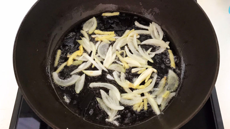 茼蒿炒鸡蛋,炒锅烧热后加入1小勺玉米油,油烧热后加入葱姜,炒出香味