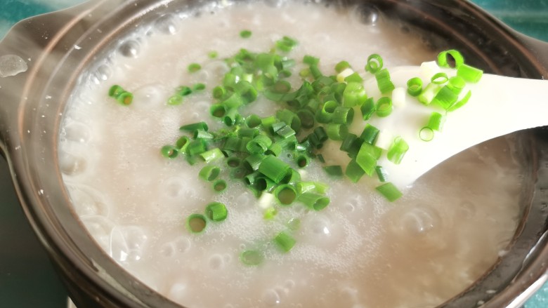 生滚牛肉粥,当牛肉变色成熟之后,加入适量葱花。