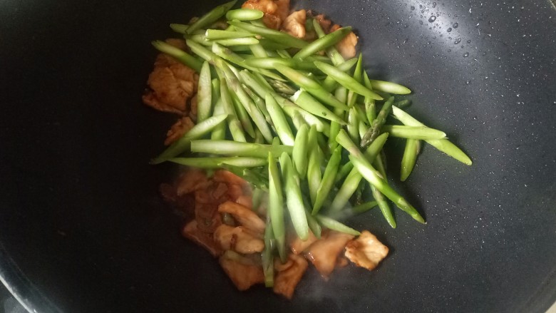 芦笋炒肉片,加入肉片,芦笋翻炒片刻