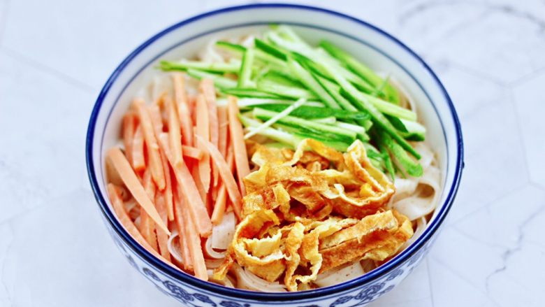 麻酱黄瓜豇豆面,上面铺上黄瓜和火腿丝,鸡蛋丝。