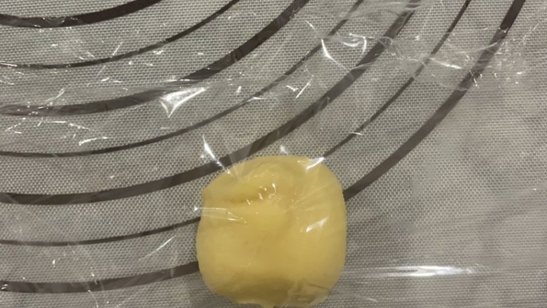 菠萝面包,酥皮两面用保鲜膜包裹后,按压,用擀面杖压成圆形