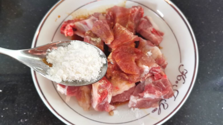 糖醋菠萝排骨,加入一勺淀粉,搅拌均匀腌制10分钟