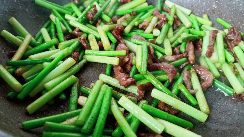 蒜苔炒牛肉,将调味料翻炒均匀即可出锅。