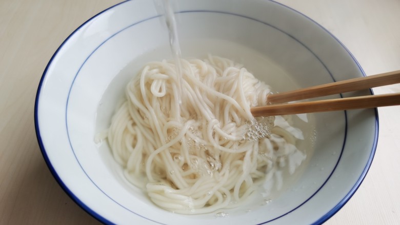 麻辣牛肉面,捞出面条，用饮用水过凉，沥干水分后放入碗里。过水后的面条吃起来更清爽筋道。