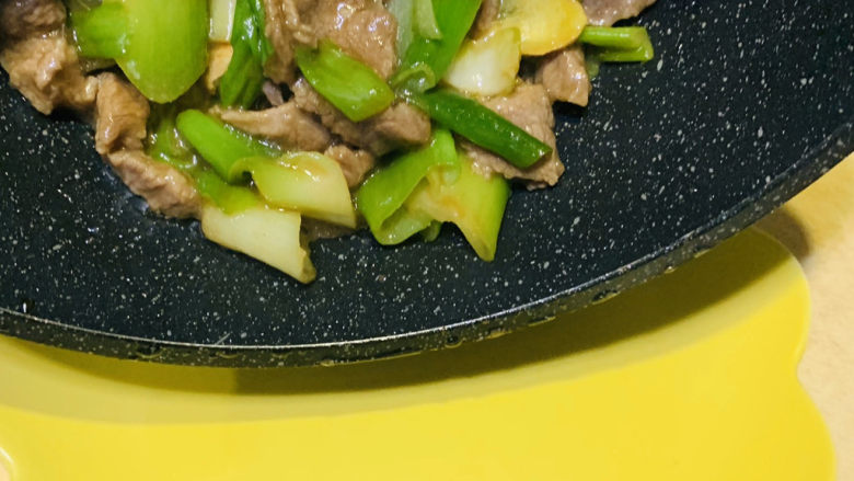 葱爆羊肉片,出锅倒入盘里;