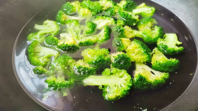 西兰花炒白玉菇,锅中加水煮开,滴几滴油,撒点盐,放西兰花焯水30秒。