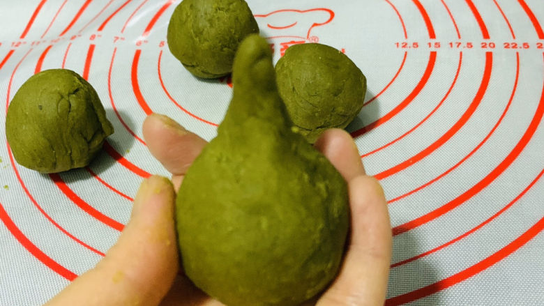 自制艾粿(清明粿、青团),搓、捏圆,尾部粘紧,去掉长的部分;