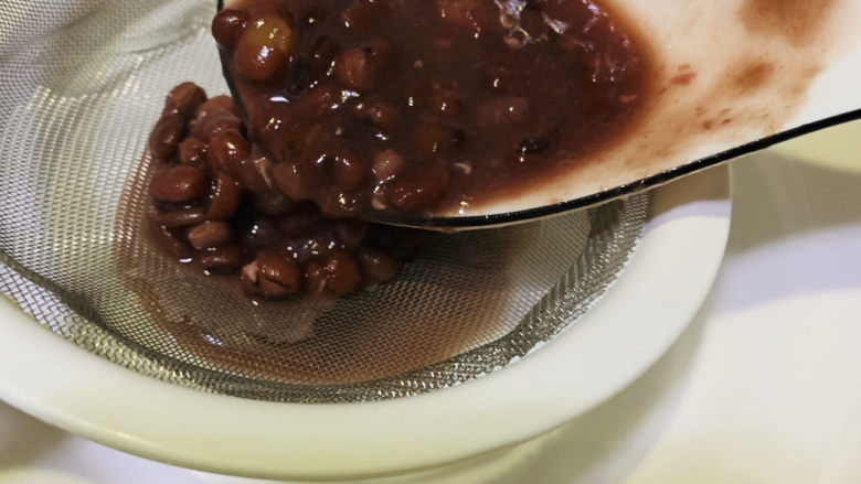 自制“红豆沙”馅,用漏勺把红豆汤过滤倒一个碗内,红豆汤可以喝,不要按压哦;