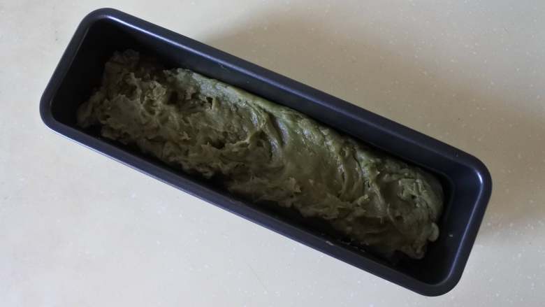 没有鱼胶粉也能做的抹茶牛奶小方,把淀粉团倒入蛋糕模具中,抹平。放置自然冷却,盖上保鲜膜进冰箱冷藏2个小时