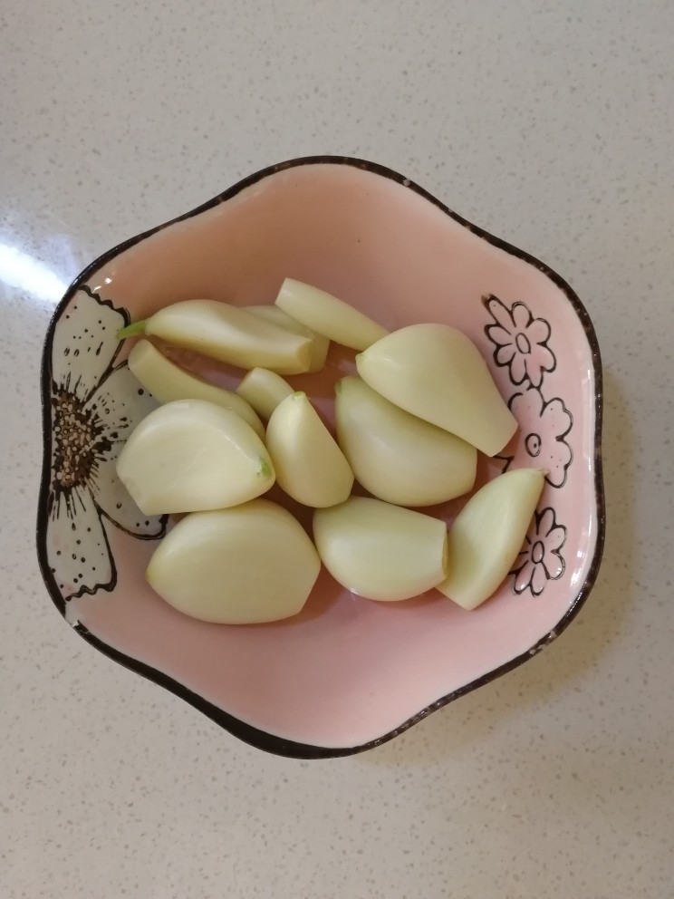 蒜泥茼蒿,扒好蒜瓣,清水冲洗,切去蒜头。