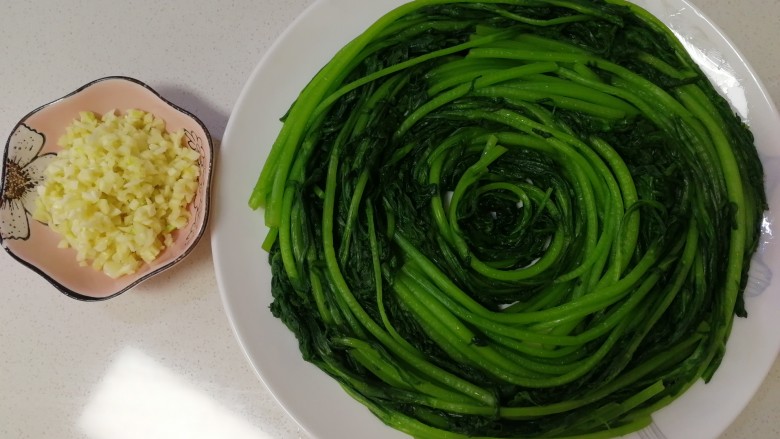 蒜泥茼蒿,蒜切末,把晾凉的茼蒿摆盘。