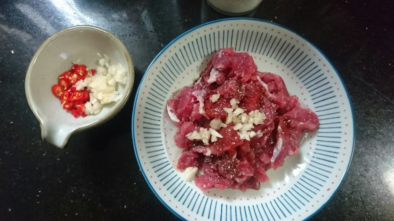 蒜苔炒牛肉,再取用少许蒜末,玉米油一同腌制