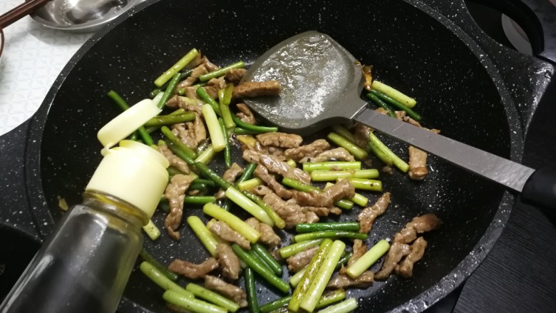 蒜苔炒牛肉,放入少许适量生抽，翻炒均匀