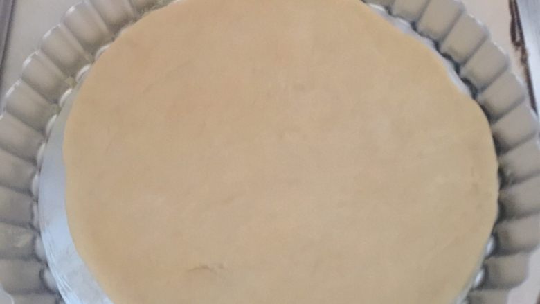 芒果披萨,发酵好的面团擀成披萨饼皮，模具刷入少量黄油，进行第二次发酵，饼皮上面要插许多小孔，发酵至两倍大。