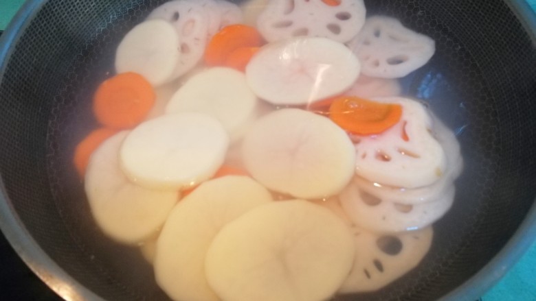 麻辣香锅,煮一锅开水,水开后放入切好的莲藕、土豆、红萝卜焯水三分钟