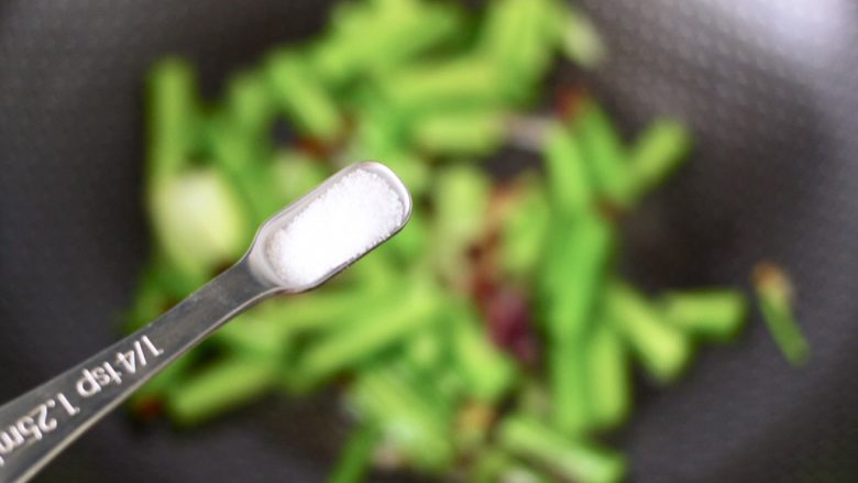 香脆椒干煸黄花鱼,加入1小勺盐调味后,继续翻炒至芹菜断生变色。