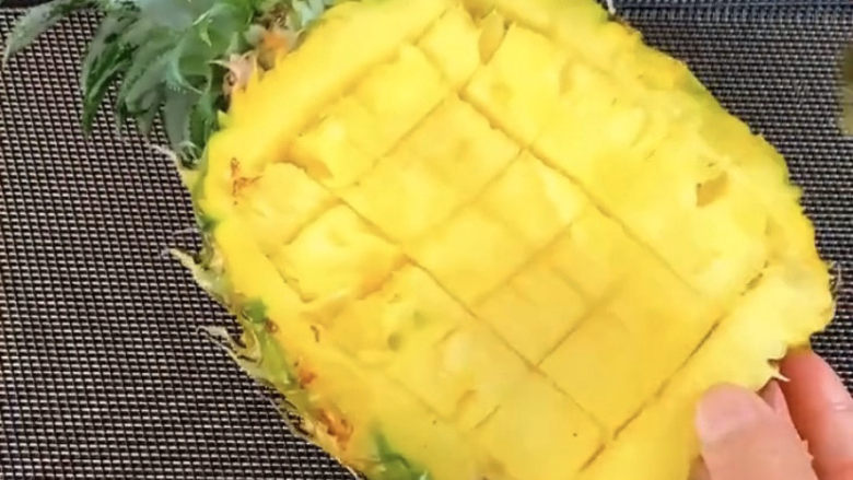 菠萝虾仁炒饭,菠萝中间切十字,方便取出果肉。