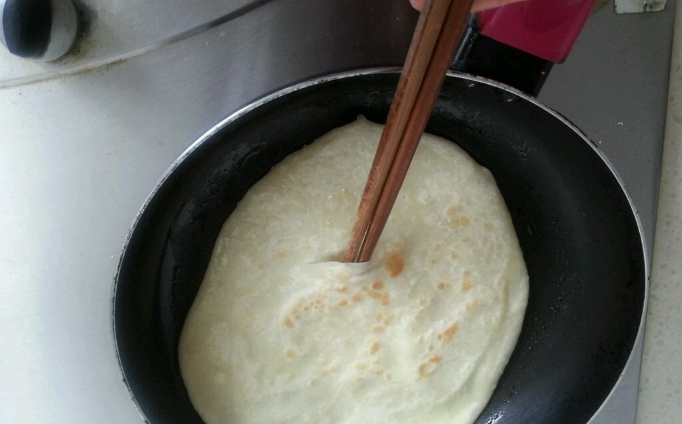鸡蛋灌饼,挑开鼓起的包包,鸡蛋倒进去,可以从洞口将筷子伸进里面,这样鸡蛋会全部灌进整个饼里;