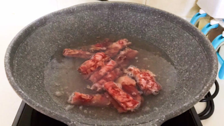 酸菜炖羊肉,锅里加入冷水,烧开后加入羊肉卷,焯水1分钟