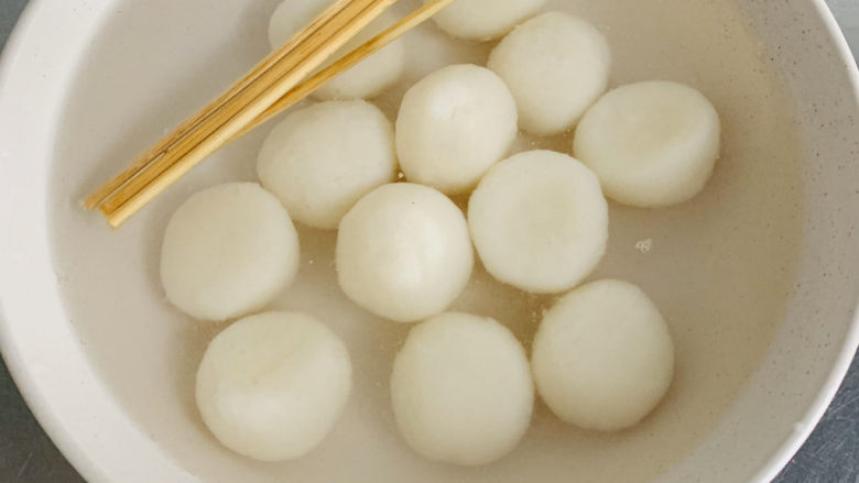 白玉丸子咖啡布丁,煮好的小丸子放入冰水中过凉。这一步也不要轻易改动冰水中哦!将清洗好的竹签将小丸子从中间穿过三个一串备用。