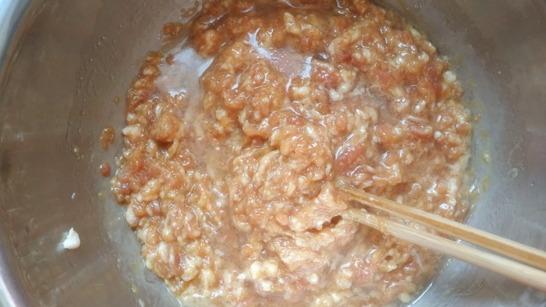 韭菜猪肉馅水饺,加入适清水,再接着划圈儿搅拌