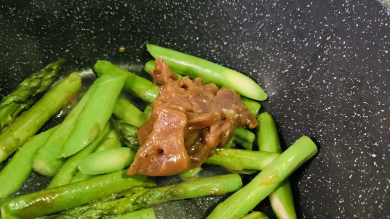 芦笋炒牛肉,加腌制好的牛肉,翻炒;